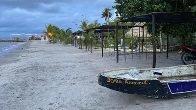 a boat sitting on a beach next to the ocean at Apartamento Atlantic 212 in La Perdiz