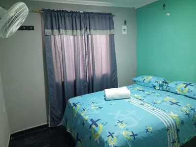 a bedroom with a bed with a blue comforter at Sharly House in Cartagena de Indias