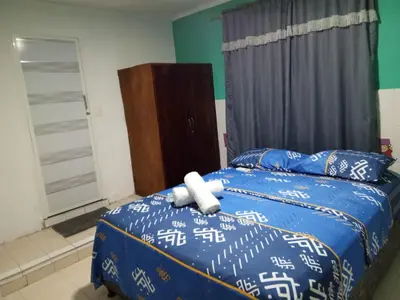 a bedroom with a bed with blue and white sheets at Sharly House in Cartagena de Indias
