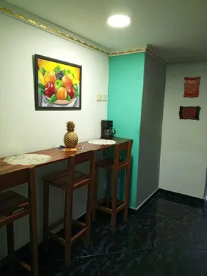 a room with two tables and a painting on the wall at Sharly House in Cartagena de Indias