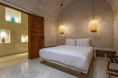 a bedroom with a large white bed and two lights at Casa Fernandez By SoHo in Cartagena de Indias