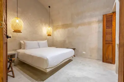 a bedroom with a white bed and two pendant lights at Casa Fernandez By SoHo in Cartagena de Indias