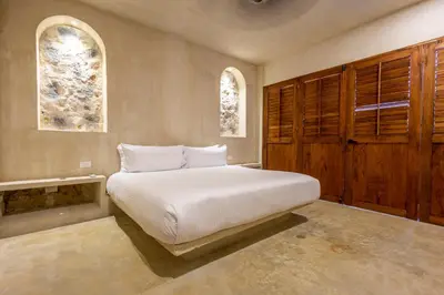 a bedroom with a white bed and two windows at Casa Fernandez By SoHo in Cartagena de Indias