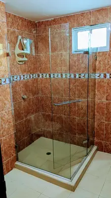a shower with a glass door in a bathroom at Me Quedo Aqui, Casa Cerca del Aeropuerto de Cartagena! in Cartagena de Indias