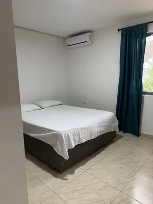 a bedroom with a white bed with a blue curtain at Casona La Española in Cartagena de Indias