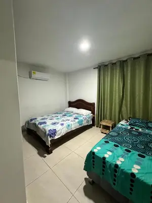 a bedroom with two beds and green curtains at Casona La Española in Cartagena de Indias
