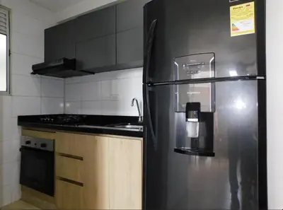 a kitchen with a black refrigerator and a stove at Apartamento en alameda del Río Conjunto Azulejo in Barranquilla