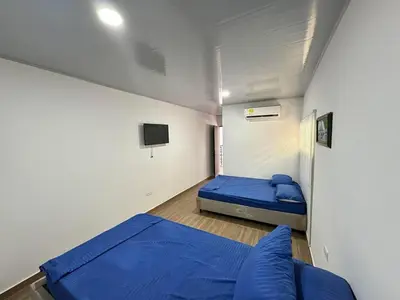 a small room with two beds and a tv at Hostal tercer cielo Restaurante Fidelio in Santa Marta