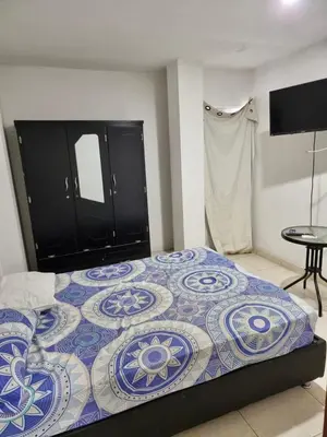 a bedroom with a bed with a blue and white quilt at Hostal tercer cielo Restaurante Fidelio in Santa Marta