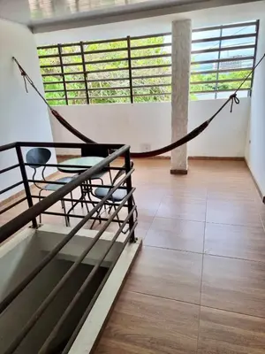 a hammock in the middle of a room with windows at Hostal tercer cielo Restaurante Fidelio in Santa Marta
