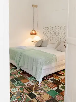 a bedroom with a bed with a patterned floor at Casa Guerrero in Cartagena de Indias