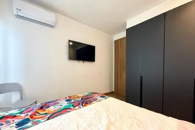 a bedroom with a bed and a tv on the wall at Vista Centro Histórico Piso 21 Piscina Infinita in Cartagena de Indias