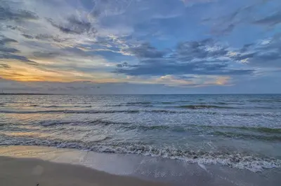 a beach with the ocean and a cloudy sky at Apartamento Atlantic 312 in La Perdiz