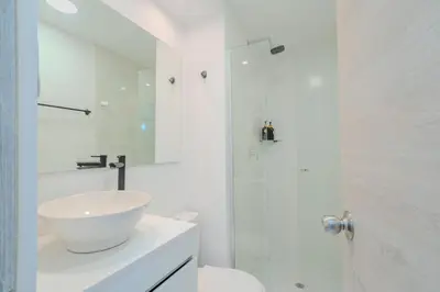 a white bathroom with a sink and a shower at Apartamento de 3 habitaciones en Cartagena cerca a la playa in Cartagena de Indias