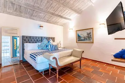 a bedroom with a king sized bed and a chair at Luxury Bryon Pool in Cartagena de Indias