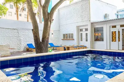a swimming pool with a tree and a building at Luxury Bryon Pool in Cartagena de Indias