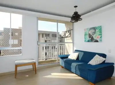 a blue couch in a living room with a window at Apartamento en alameda del Río in Barranquilla