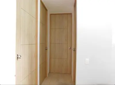 a closet with wooden doors in a room at Apartamento en alameda del Río in Barranquilla