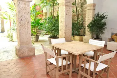 a wooden table and chairs in a room with plants at Charming 1BR apartment in the Heart of Cartagena's Old City in Cartagena de Indias