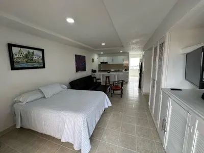 a bedroom with a bed and a living room at Apartamentos En Edificio Portofino ICDI in Cartagena de Indias