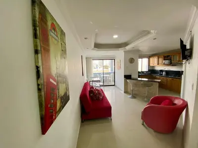 a living room with a red couch and a red chair at Apartamentos En Edificio Portofino ICDI in Cartagena de Indias