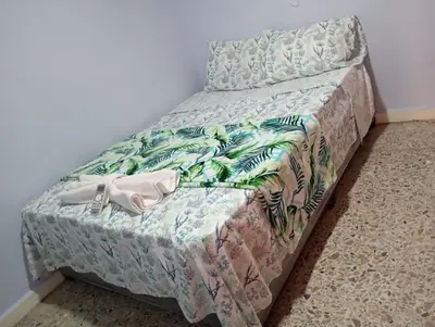 a small bed in a room with a bedspread on it at El reposo real in Barranquilla