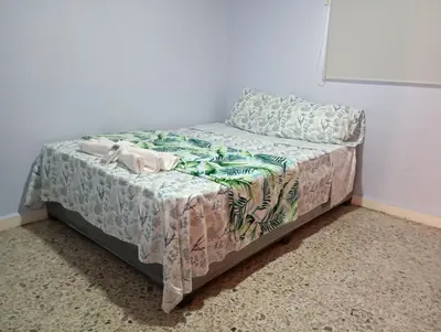 a small bed in a room with a bedspread at El reposo real in Barranquilla