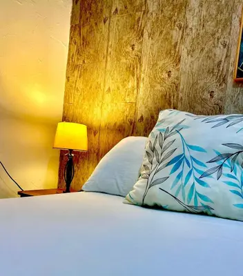 a bed with blue and white pillows next to a lamp at Casa Centro Historico Hotel in Cartagena de Indias