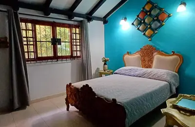 a bedroom with a bed with blue walls and a window at Habitación con baño privado en el corazón de Manga in Cartagena de Indias