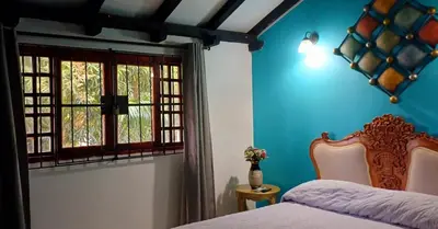 a bedroom with blue walls and a bed and a window at Habitación con baño privado en el corazón de Manga in Cartagena de Indias