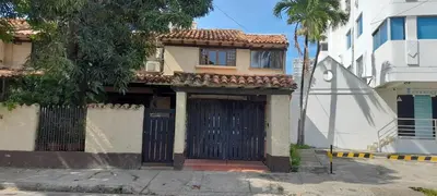a building with a door and a palm tree at Habitación con baño privado en el corazón de Manga in Cartagena de Indias
