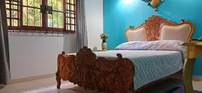 a bed in a room with a blue wall at Habitación con baño privado en el corazón de Manga in Cartagena de Indias