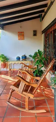 a pair of wooden chairs sitting on a porch at Habitación con baño privado en el corazón de Manga in Cartagena de Indias