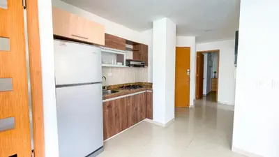 a kitchen with a white refrigerator and wooden cabinets at Hermoso Apartamento Frente al Mar 2 Habitaciones B12A in Coveñas