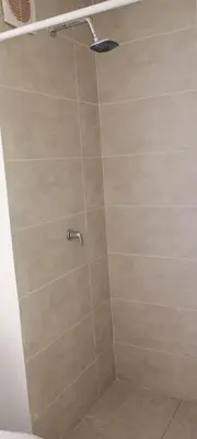 a shower with a beige tiled wall at Apartamento Manglar C Mallorquin Vista al Mar in Puerto Colombia