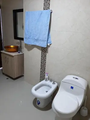 a bathroom with a white toilet and a blue towel at Appartamento Italian Style in Cartagena de Indias