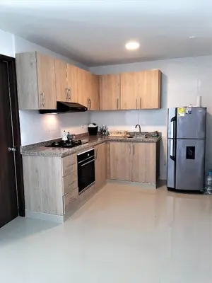 a kitchen with wooden cabinets and a stainless steel refrigerator at Appartamento Italian Style in Cartagena de Indias