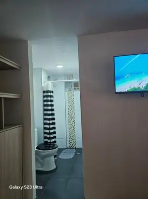 a bathroom with a toilet and a television on the wall at Hermoso apartamento familiar! exento de IVA in Barranquilla