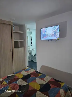 a bedroom with a bed and a tv on the wall at Hermoso apartamento familiar! exento de IVA in Barranquilla