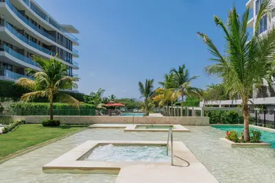 a pool at a resort with palm trees and a building at Exclusive Loft In Cartagena By Huepedia in Cartagena de Indias