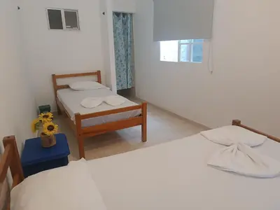 a bedroom with two beds and a table with flowers at Casa Luna in Santa Veronica