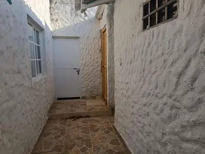 an alley with a white door and a window and a building at Casa Luna in Santa Veronica
