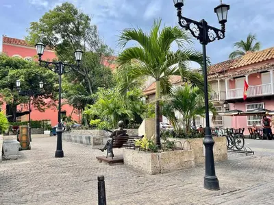 a street light with a statue sitting on a bench at Walled City apt- Rooftop Pool & Private Garden in Cartagena de Indias