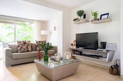 a living room with a couch and a tv at Walled City apt- Rooftop Pool & Private Garden in Cartagena de Indias