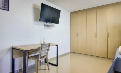 a desk with a chair and a television on a wall at Precioso Apartamento Duplex en gran ubicación in Barranquilla
