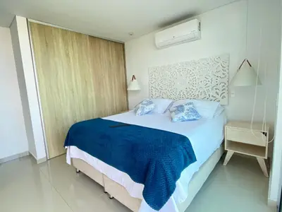 a bedroom with a bed with blue sheets and a window at Melodias de Verano in Cartagena de Indias