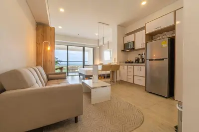 a living room with a couch and a kitchen at CB1135 | Suite balcón privado y vista relajante in Cartagena de Indias