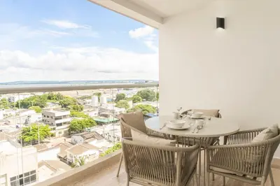 a dining room with a table and chairs and a large window at Vista increíble + balcón soñado cerca del mar CB942 in Cartagena de Indias