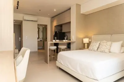 a bedroom with a white bed and a kitchen at Vista increíble + balcón soñado cerca del mar CB942 in Cartagena de Indias