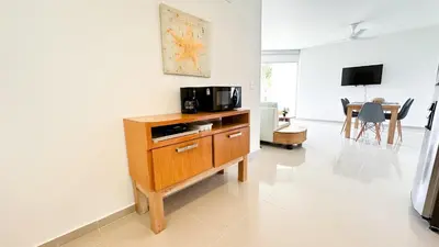 a living room with a microwave and a table at Hermoso Apartamento Frente al Mar 2 Habitaciones B12B in Coveñas